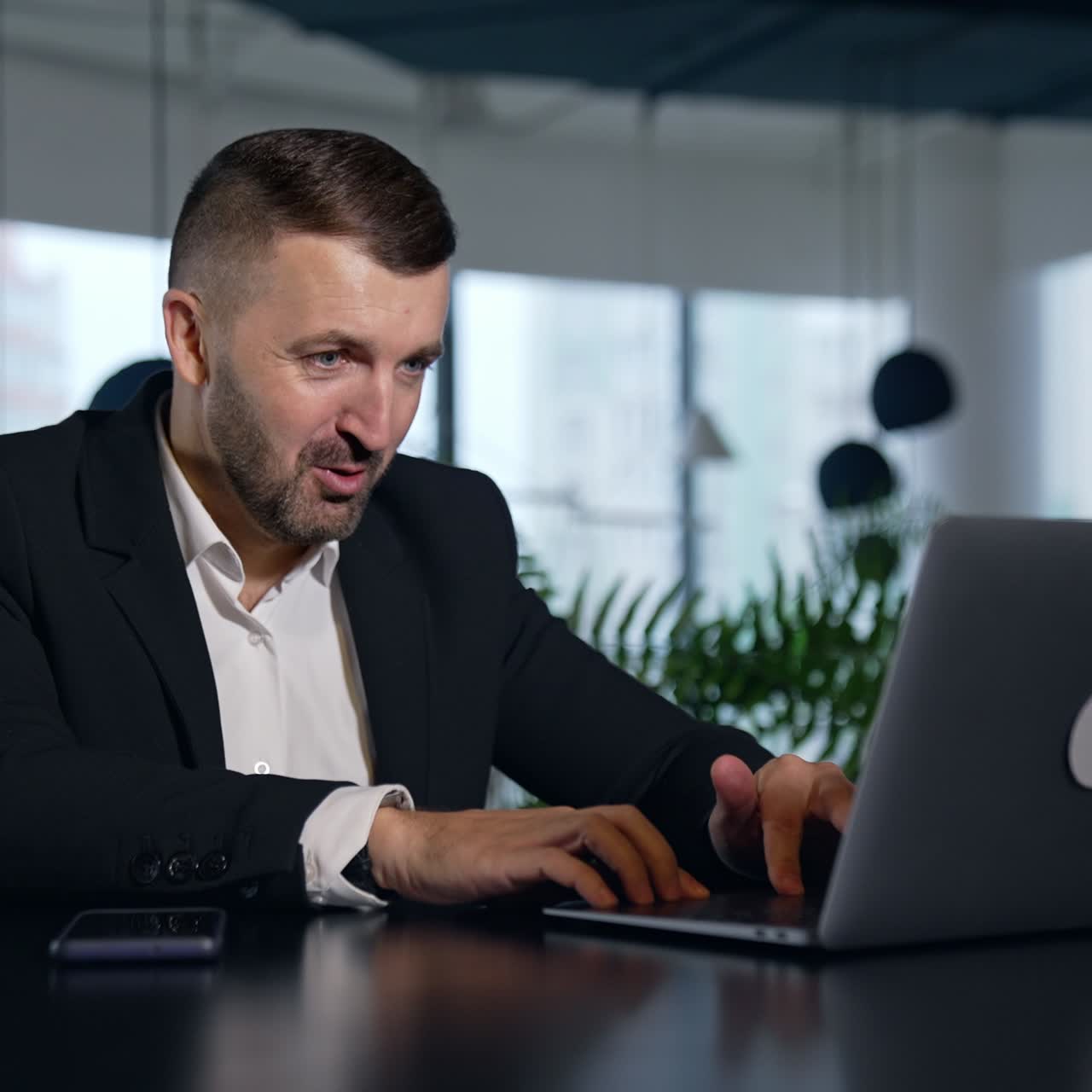 Successful businessman working in modern office. Happy confident smart young office worker