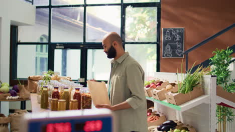 man filling in paper bag with pasta