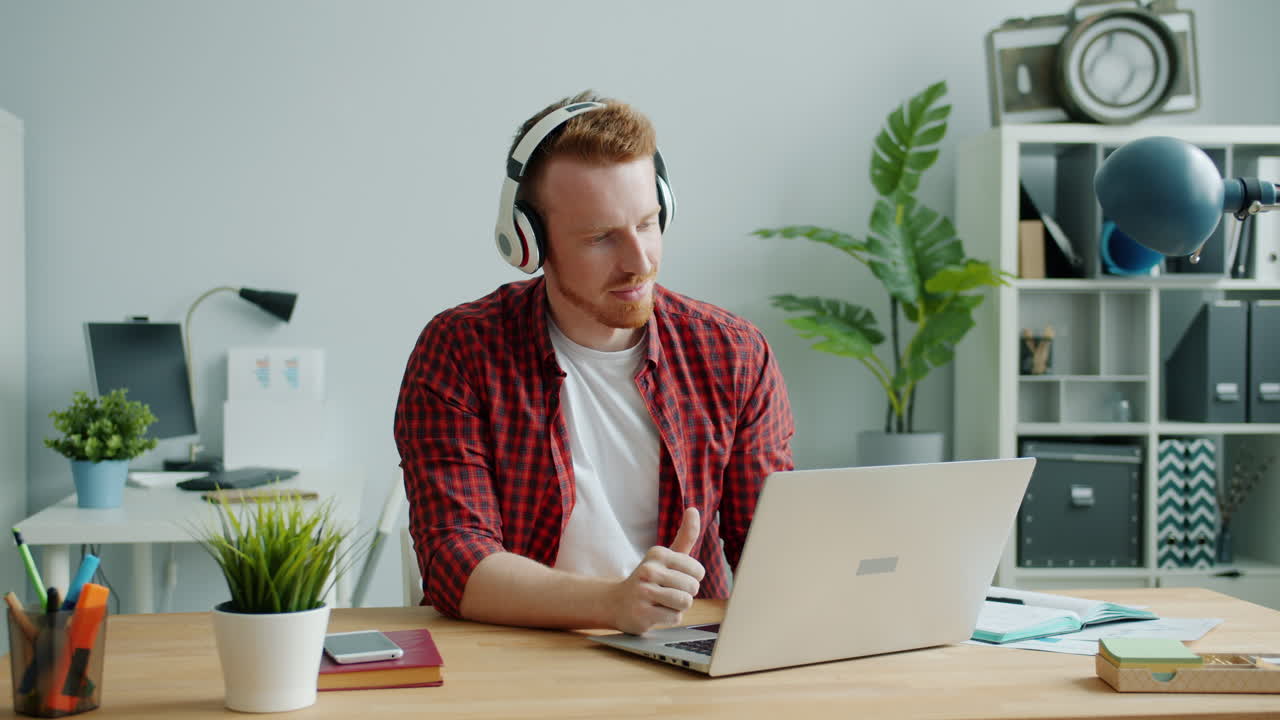 hombre trabajando en una computadora portátil con auriculares