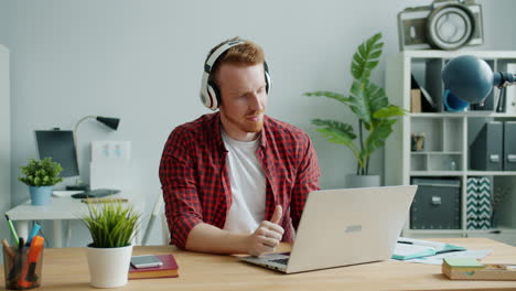man working on laptop with headphones