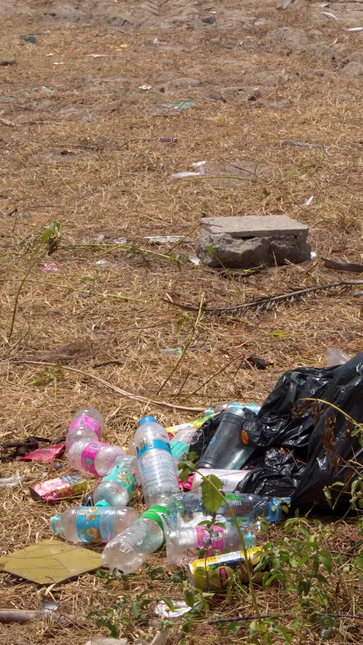 Environmental Pollution: Plastic Bottles and Trash on Dry Ground