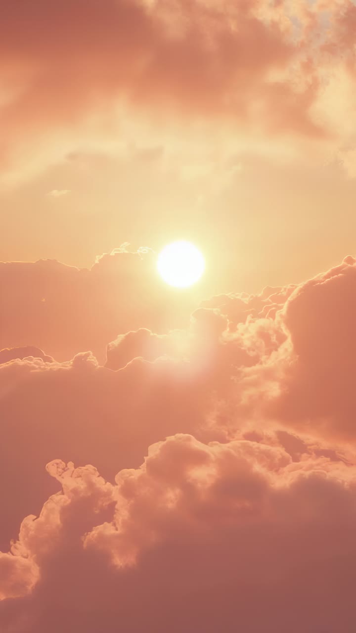 Vertical video: Shining sun and cloud bank casting moving glow during sunrise, with cirrus