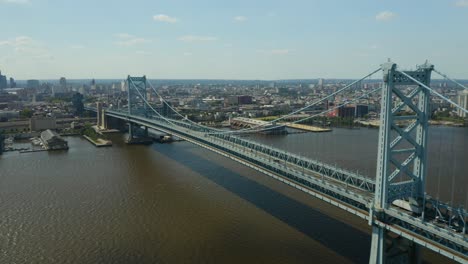 aerial - tractor trailer crosses over bridge to enter urban city