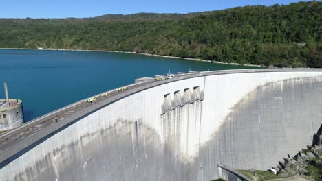 drone tracking shot of a group of tourists visiting a dam in summertime