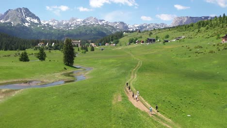 running through mountains, river, green grass and blue sky