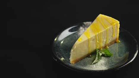 a piece of lemon sweet dessert on a plate on a black background.