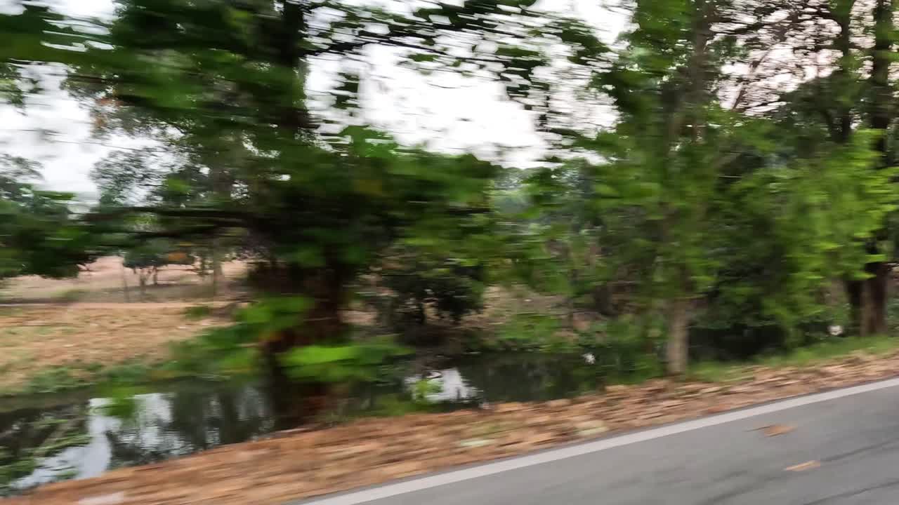 Passando accanto ad alberi, un canale e un veicolo parcheggiato