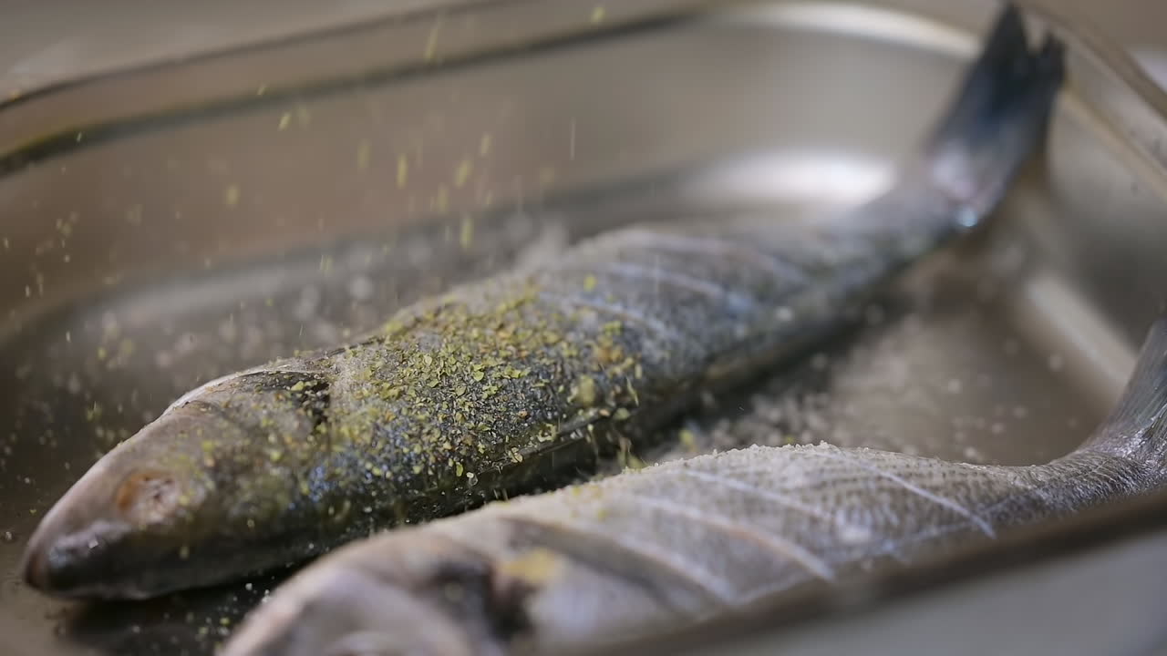 Prepares food in the kitchen. Close up of fish preparing in the kitchen