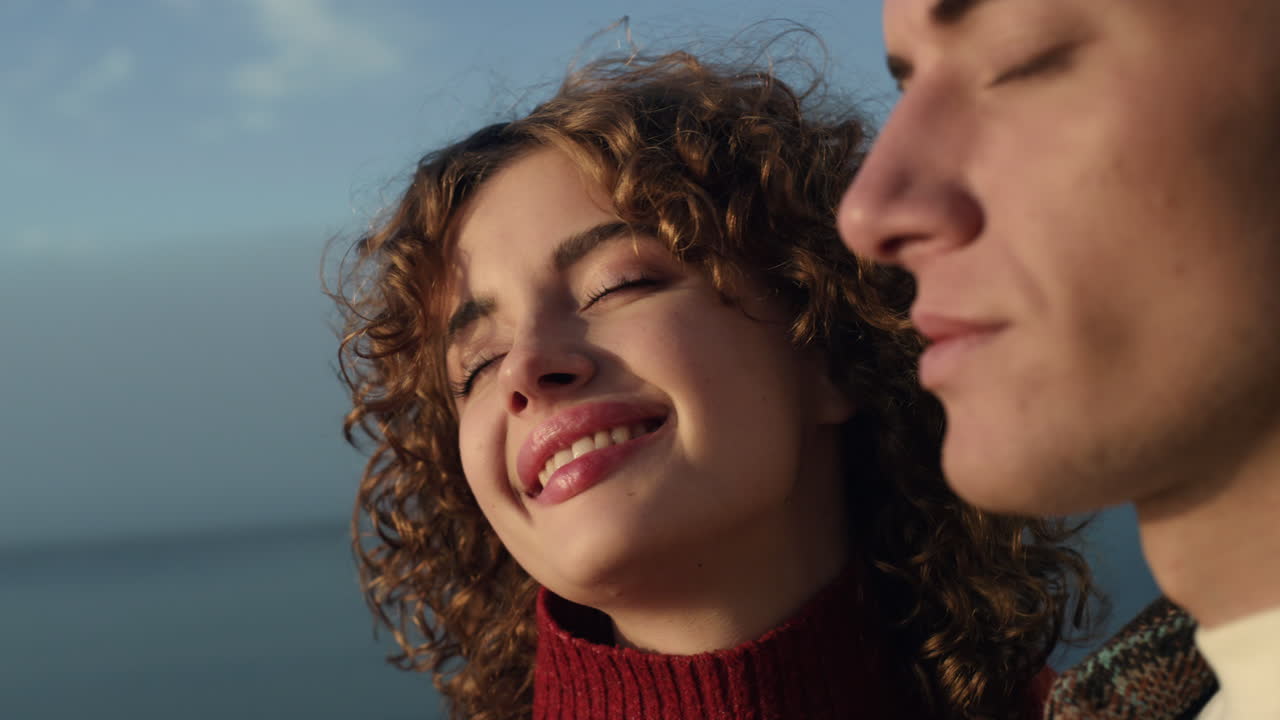 Mutlu çift denizde romantik anlar yaşıyor. Gözleri kapalı, hayallere dalmış kız ve erkek.