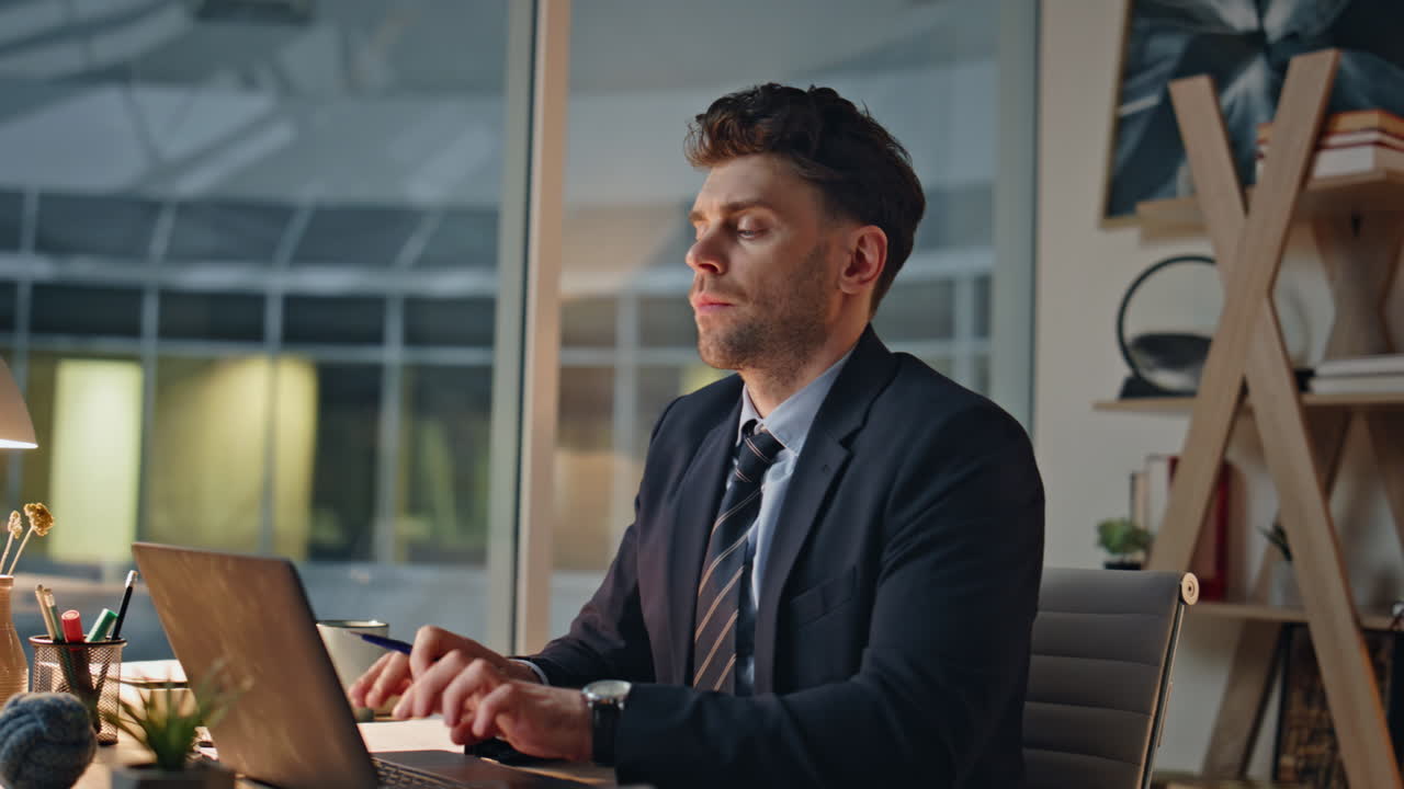 Evening manager surfing internet at laptop sitting corporate office closeup