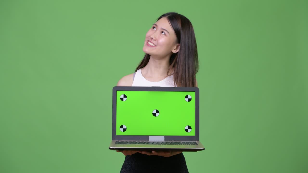 Young beautiful Asian businesswoman showing laptop