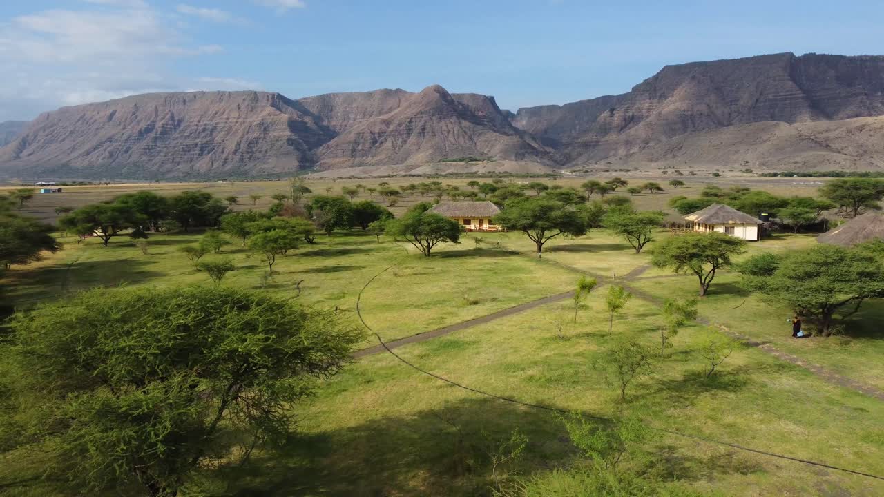A charming little African village surrounded by trees and the amazing mountains of Tanzania, very close to Lake Natron in Africa