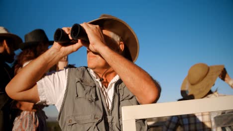 amigos mirando a través de binoculares durante las vacaciones de safari 4k