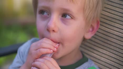 Un-Lindo-Niño-Rubio-Disfrutando-De-Un-Helado-En-Un-Caluroso-Día-De-Verano,-Cámara-Lenta