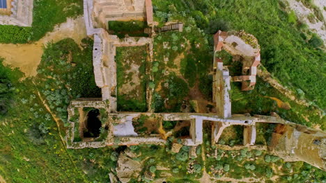 aerial bird's eye view of ruins of an old building on the hill top with lush green vegetation in north of troina, sicily, italy at daytime