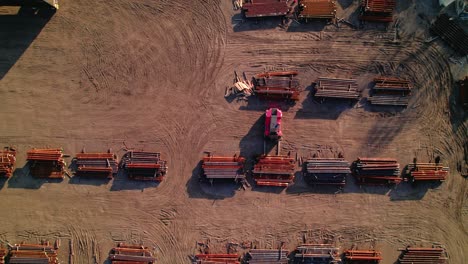 Forklift-Loading-rusted-steel-bar-on-industrial-yard-full-of-staked-metal-bars