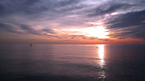 océanos al atardecer. hombre en una tabla de surf al atardecer océano. océanos al atardecer con aguas tranquilas