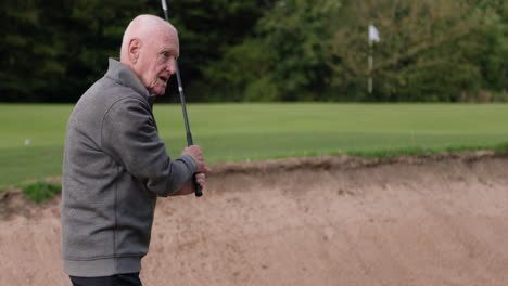 Senior golfer playing in a sand trap