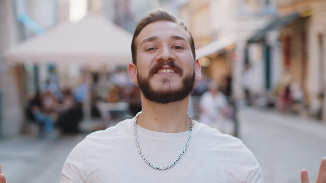 Young man looking surprised at camera shocked by sudden win good victory news wow in city street