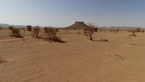 riding through the sahara desert sands in morocco towards a butte