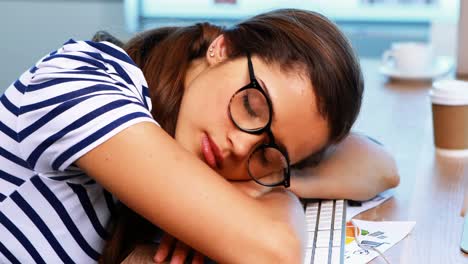 una diseñadora gráfica durmiendo en un escritorio