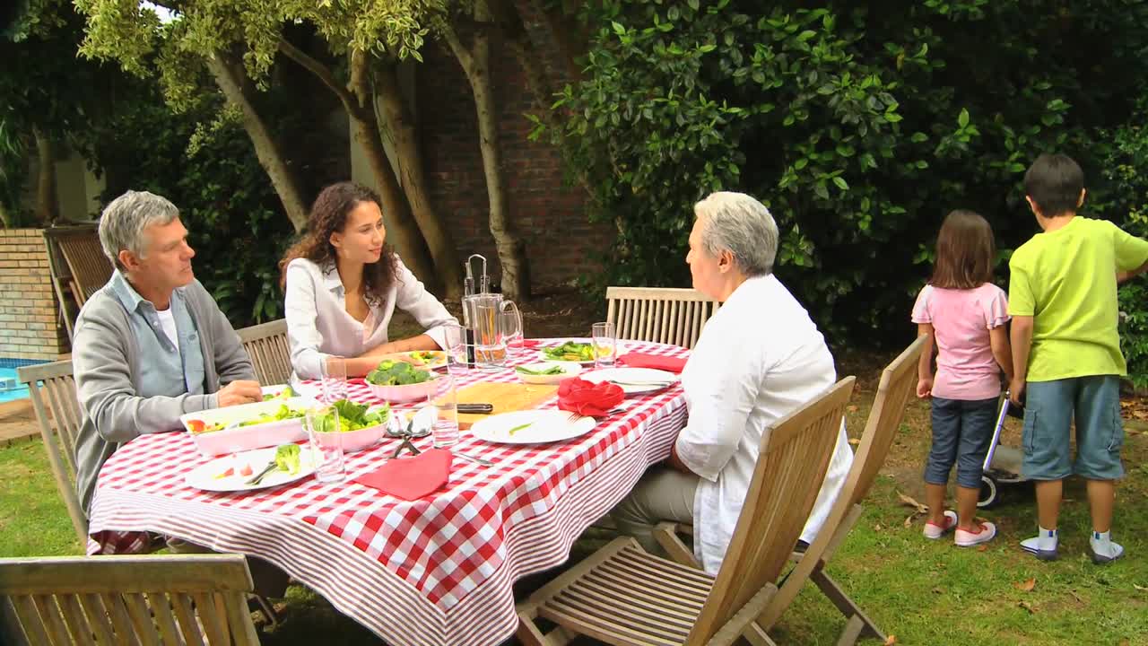 niños ayudando con el almuerzo de barbacoa en el jardín