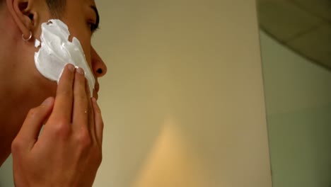 Man-applying-shaving-cream-on-his-face-at-bathroom-4k