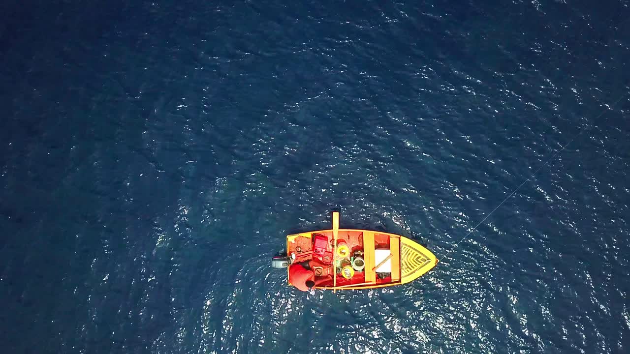 vista aérea de un pescador en su barco rojo en un día soleado, costas de curacao, isla caribeña holandesa