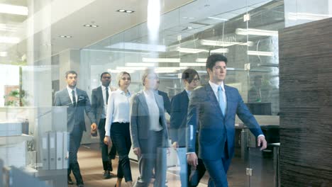 diverse team of delegates/ lawyers confidently marching through the corporate building hallway. multicultural crowd of resolute business people in stylish marble and glass offices.