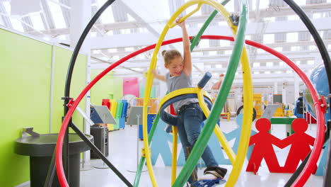 young girl having fun on human gyroscope at a science centre