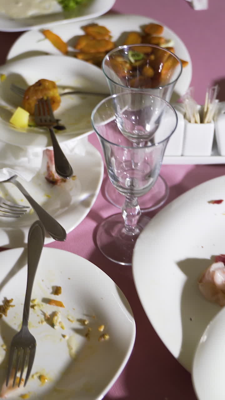 dirty dishes are on the table after a feast. Leftovers after the celebration Vertical video
