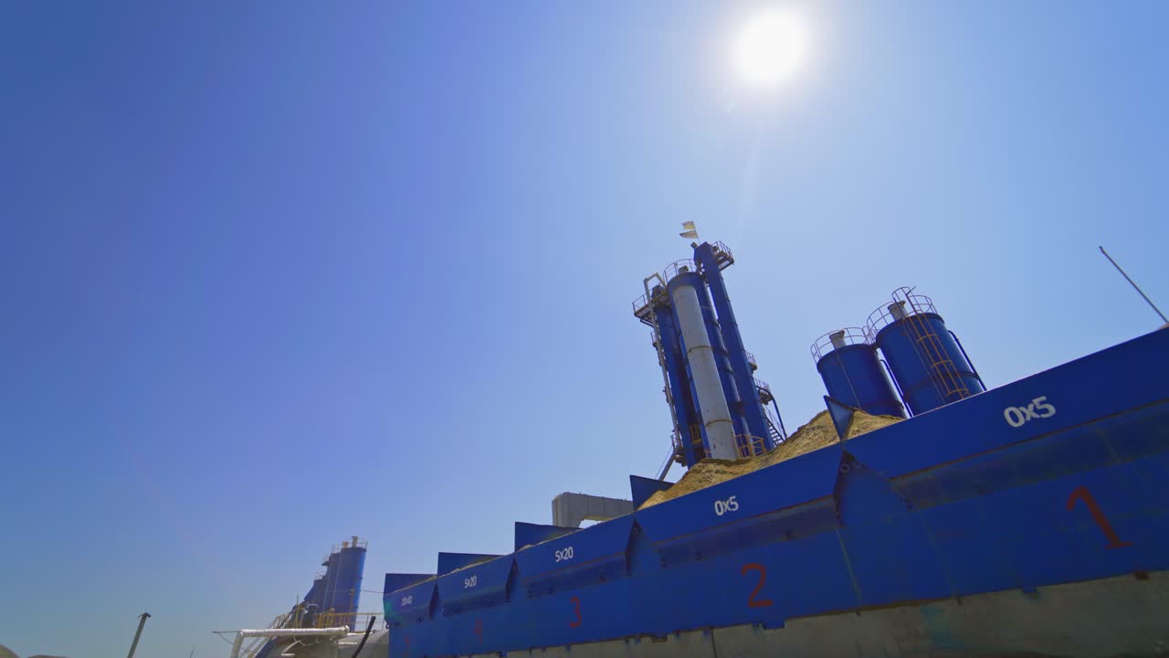 Modern industrial plant outdoors. Asphalt plant. View from below. Contemporary metal construction of manufacturing.