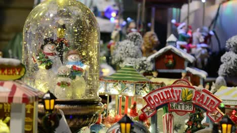 christmas toys, snowball and carousel with multi-colored lights in a christmas market