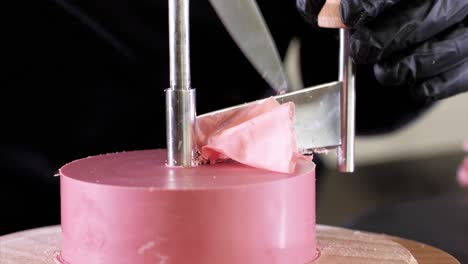 el confitero está haciendo pétalos de chocolate rosa en un cortador redondo