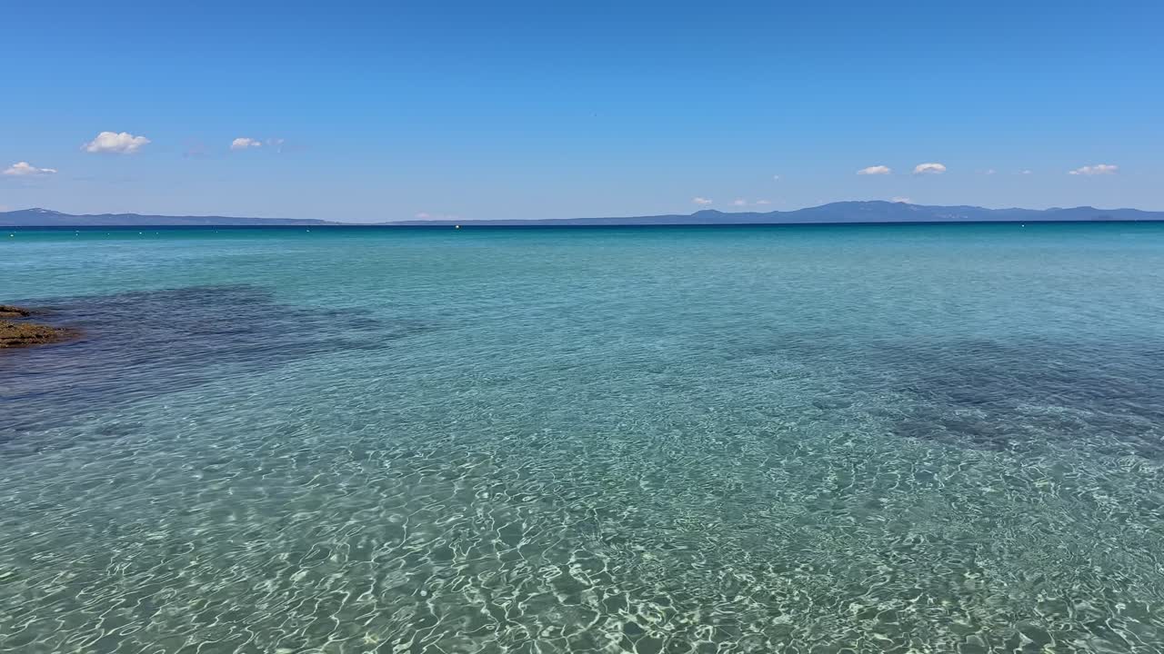 Stunning beach scene in Halkidiki, Greece, with elegant sunbeds facing the crystal-clear turquoise sea. A perfect summer escape in the heart of the Aegean.