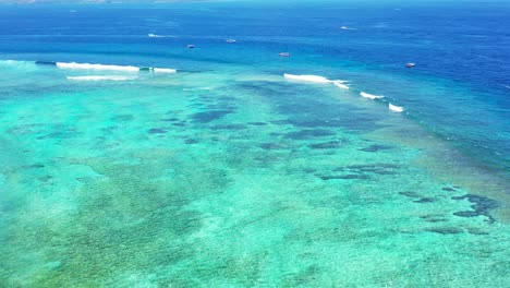 Boote-Segeln-Im-Wunderschönen-Türkisfarbenen,-Flachen-Meerwasser-Und-Im-Gesunden-Korallenriff