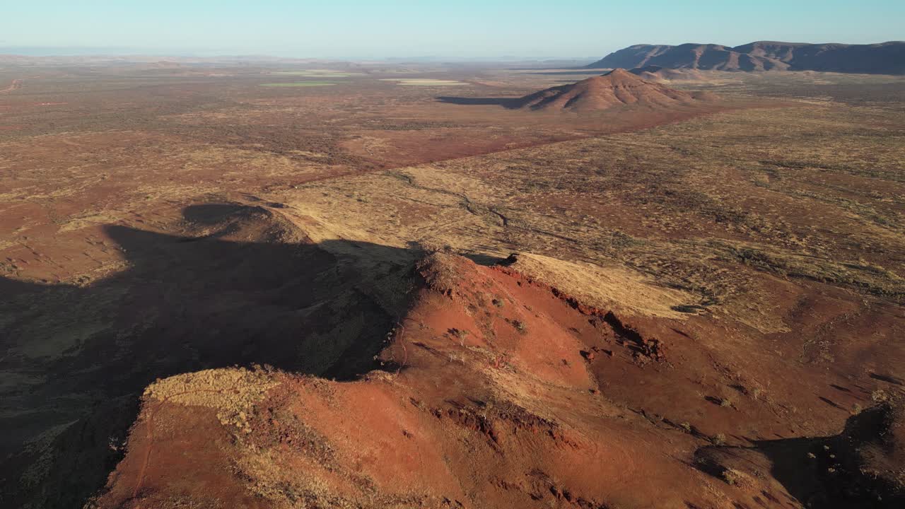 monte bruce en el medio del desierto australiano durante el atardecer con largas sombras, aérea