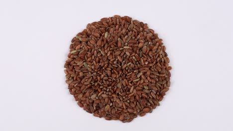Rotating raw red rice on the turn table isolated on white background. View from the top.