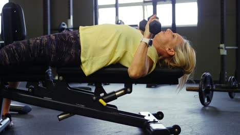 senior woman doing chest press workout with dumbbell 4k