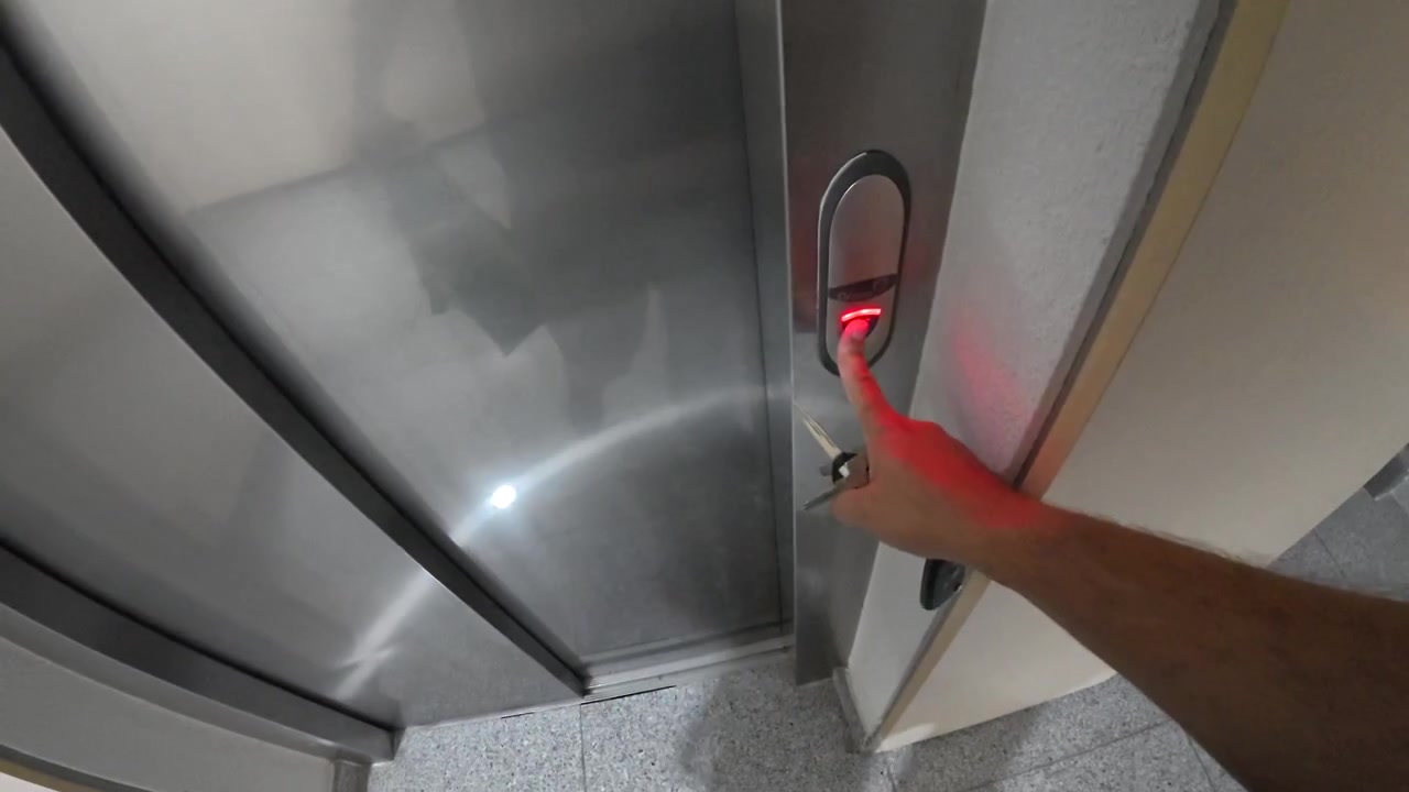 Person Waiting for Elevator in Apartment Building Hallway