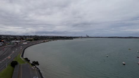 Aerial-Dolly-of-a-Busy-Northcote-Point-Highway-Along-the-Oneoneroa-Shoal-Bay,-Auckland,-New-Zealand