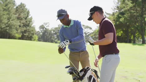 video of diverse male friends preparing golf clubs for paying on golf field