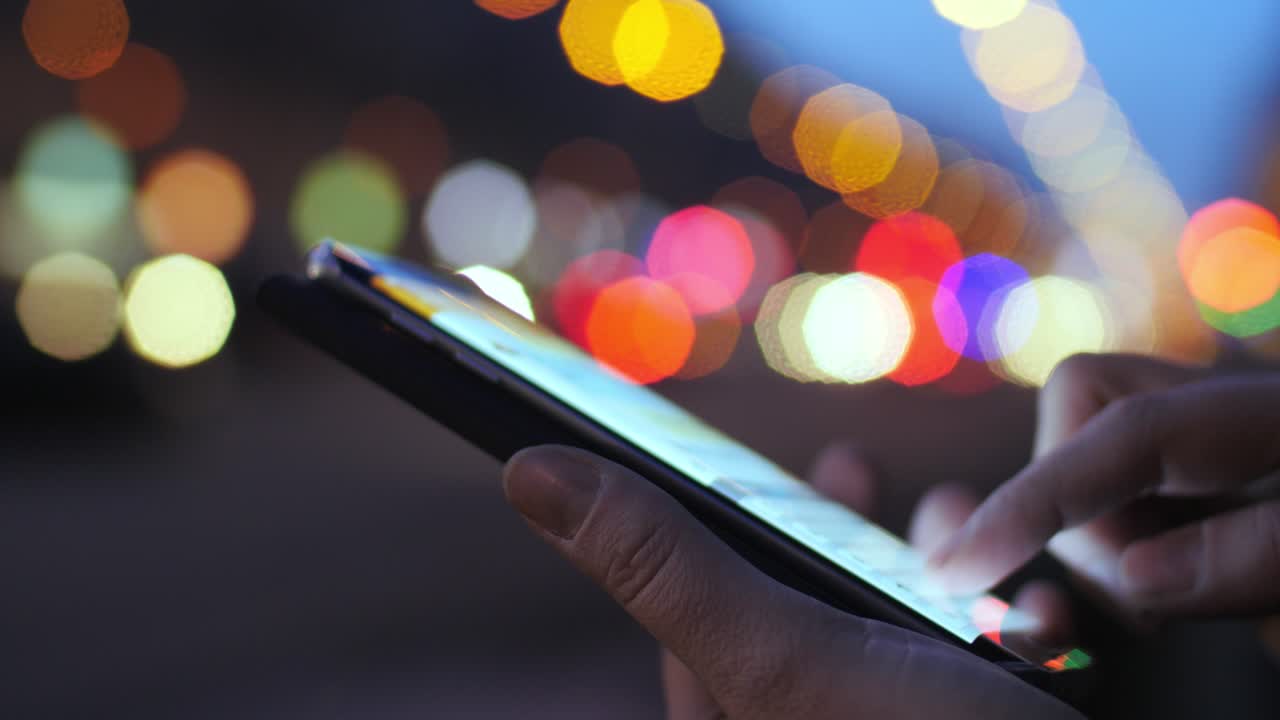 Texting sms on background of city and transport lights