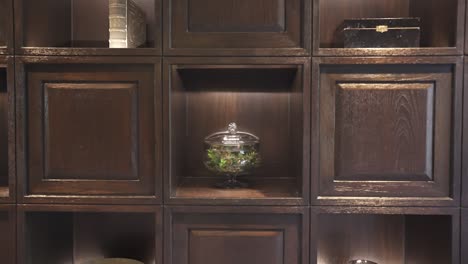 a close view of a dark wooden bookshelf filled with various decorative items and books