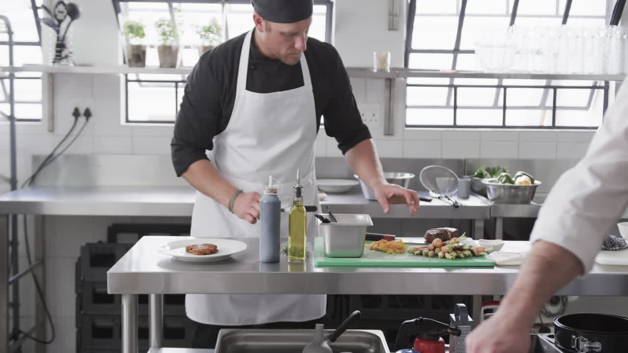grupo de diversos cocineros masculinos preparando comidas en la cocina, cámara lenta