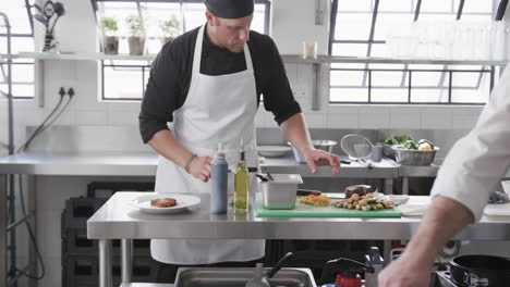 grupo de diversos cocineros masculinos preparando comidas en la cocina, cámara lenta