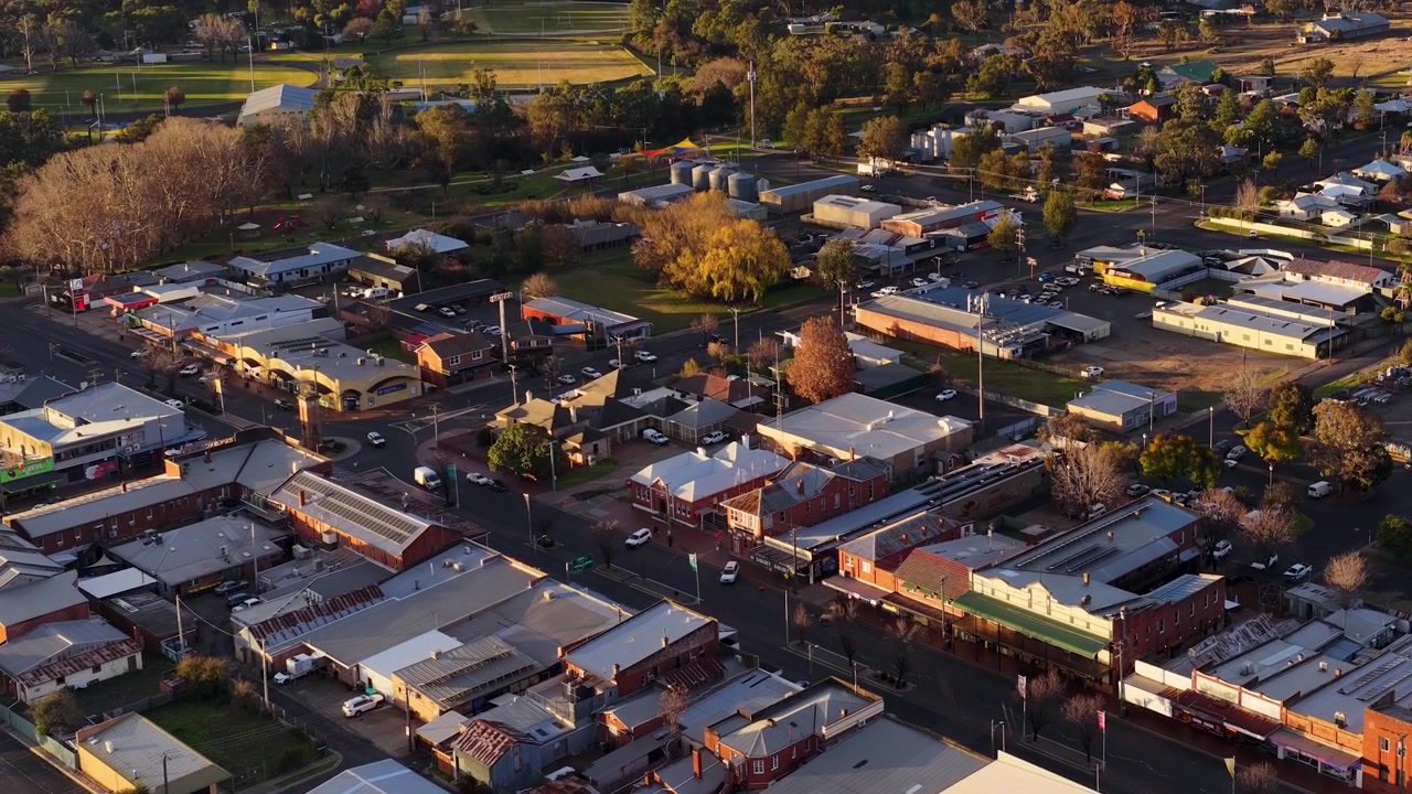 Ripresa aerea con drone dall'alto della griglia stradale di una piccola città durante l'ora d'oro in Australia