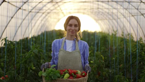 joyful woman walking with basket with fresh harvested greens and peppers