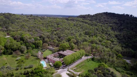 En-Medio-Del-Abrazo-Sereno-Del-Bosque,-Una-Casa-Con-Una-Piscina-Cristalina-Toma-Protagonismo,-Formando-Un-Oasis-De-Tranquilidad-Enclavado-Armoniosamente-Dentro-De-La-Exuberante-Vegetación