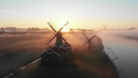 Windmill-De-Jonge-Dirk-Während-Eines-Nebligen-Sonnenaufgangs-An-Der-Zaanse-Schans-Ein-Langsamer-Schwenk-Filmischer-Drohne-Aus-Der-Luft-In-4k